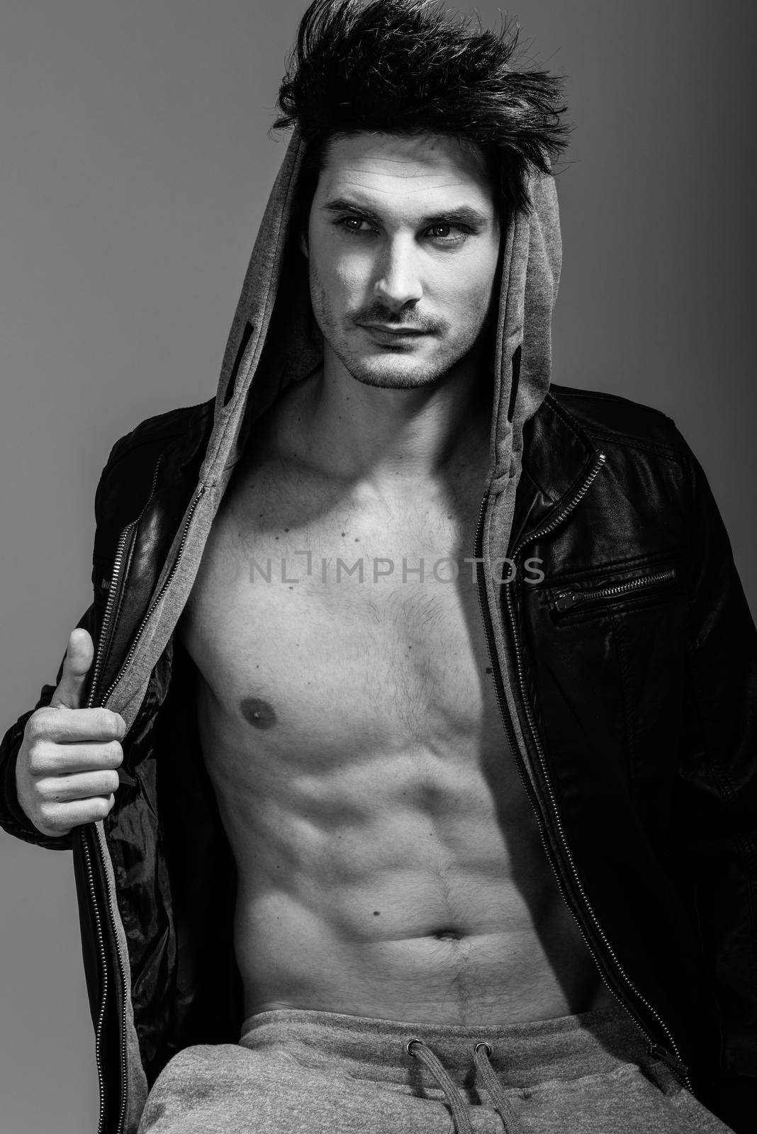 Portrait of athletic man wearing hoodie jacket. Studio shot