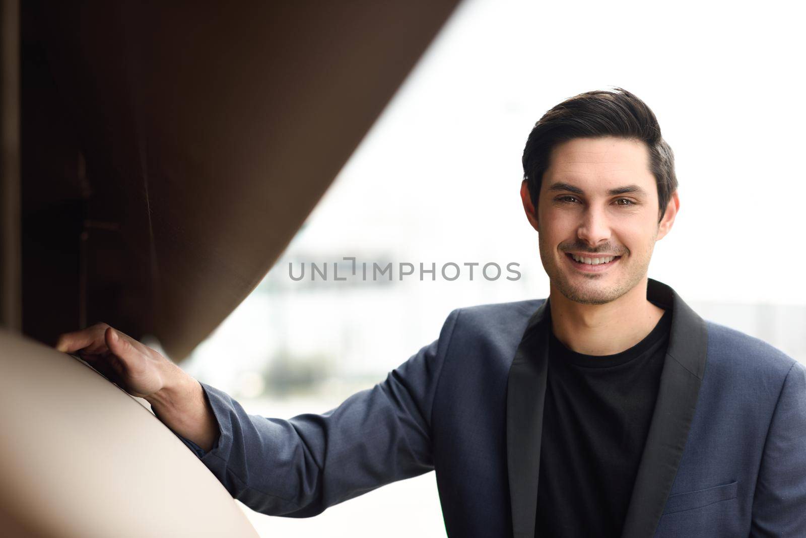 Portrait of an attractive man, model of fashion, wearing modern suit.