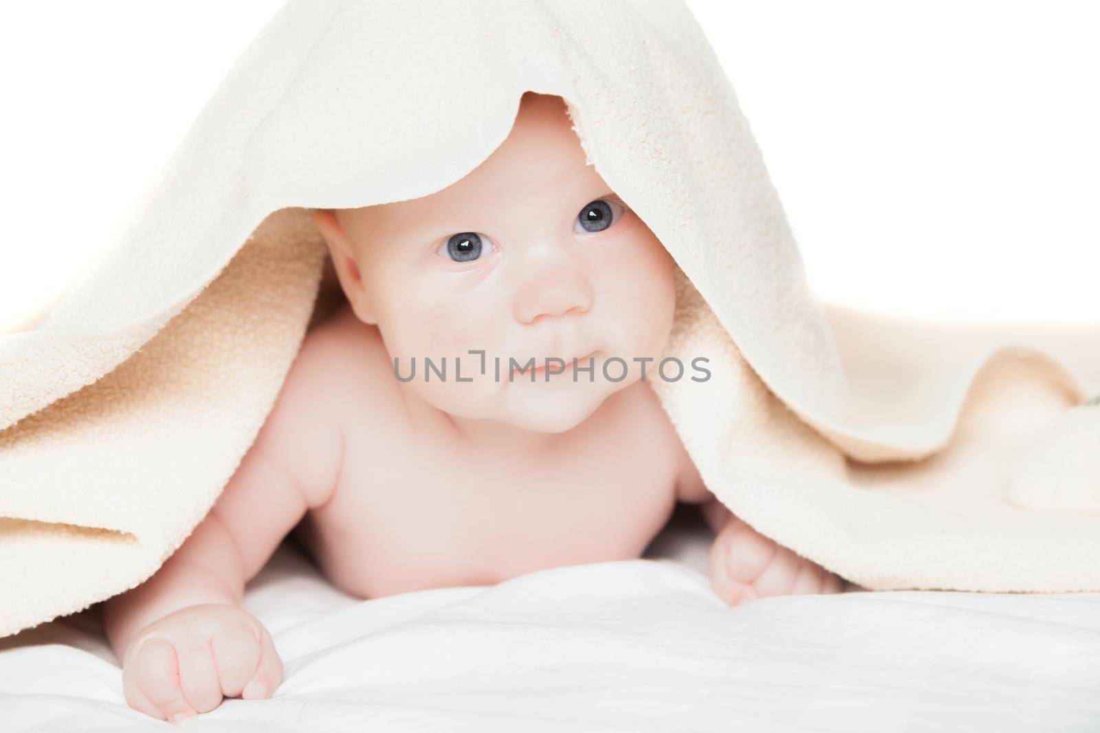 Cute baby under the towel after bathing on white background