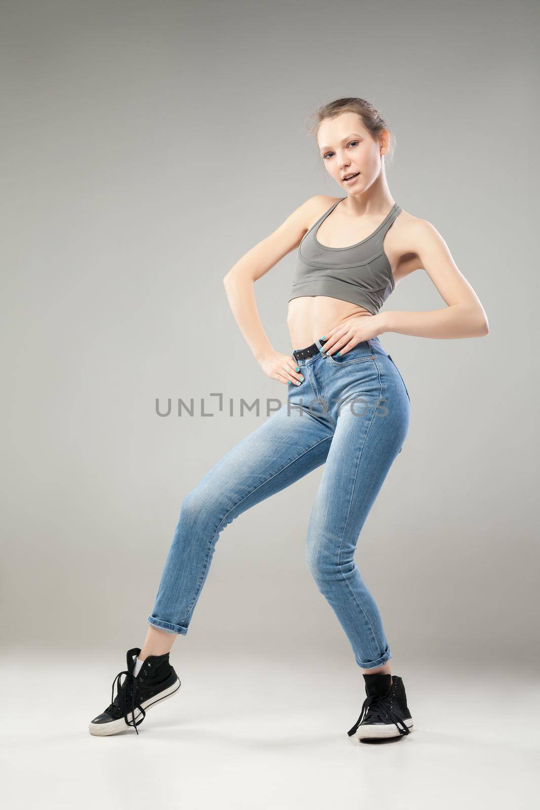 Portrait of cheerful woman looking at camera while dancing. Studio shot