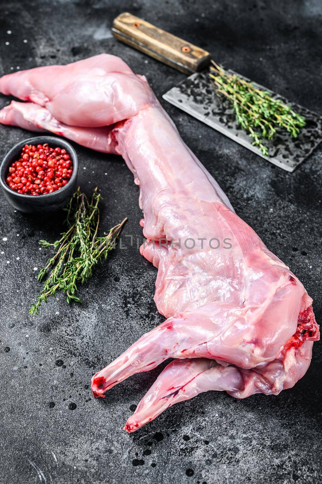 Whole raw rabbit with cooking spices. Black background. Top view by Composter
