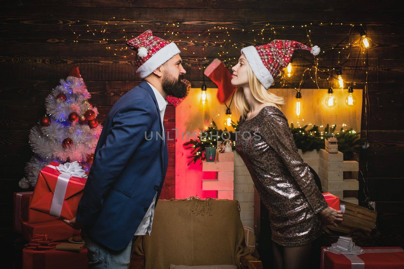 Christmas kiss of couple in love. Portrait of surprised and funny couple. Comic couple with surprise gift. by Tverdokhlib