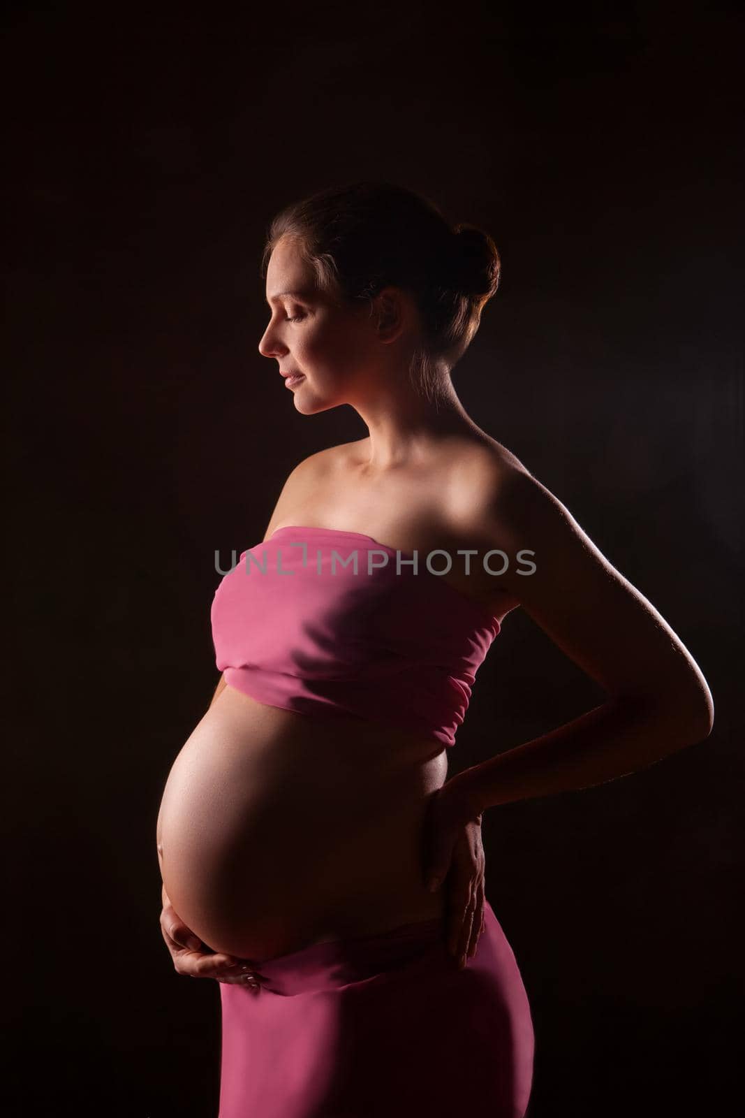 Portrait of beautiful pregnant woman in pink chiffon shawl