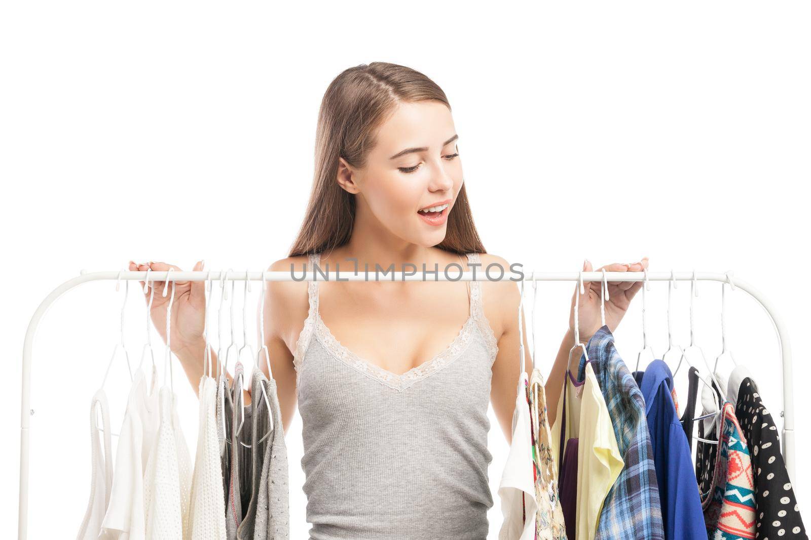 Portrait of smiling brunette looking down at clothes on hanger