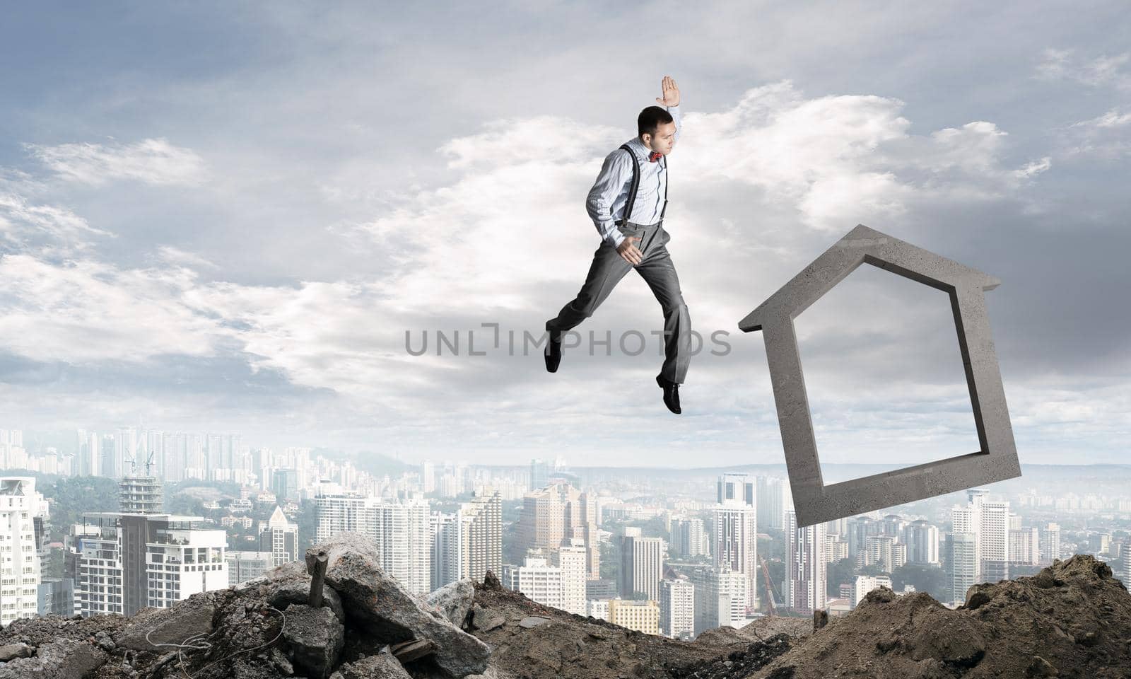 Jumping businessman crashing big house symbol with city view on background. 3D rendering.