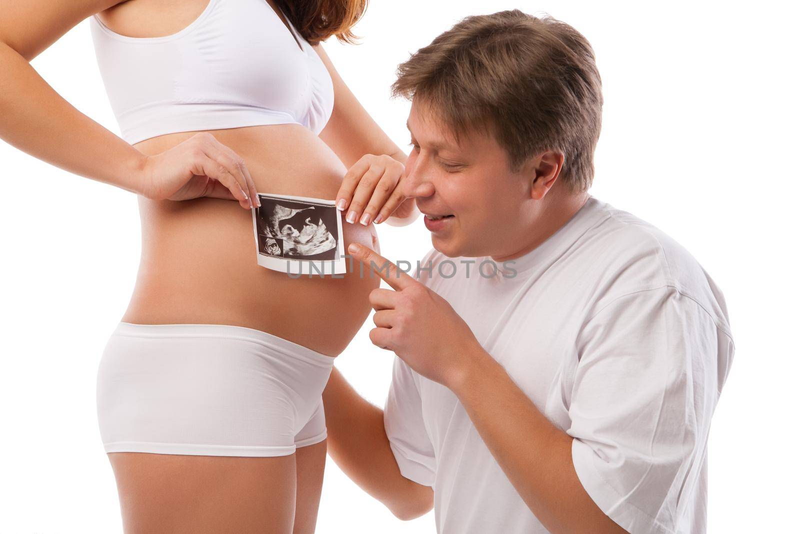 Pregnant woman and her husband is holding her stomach and a photo of her Ultrasound