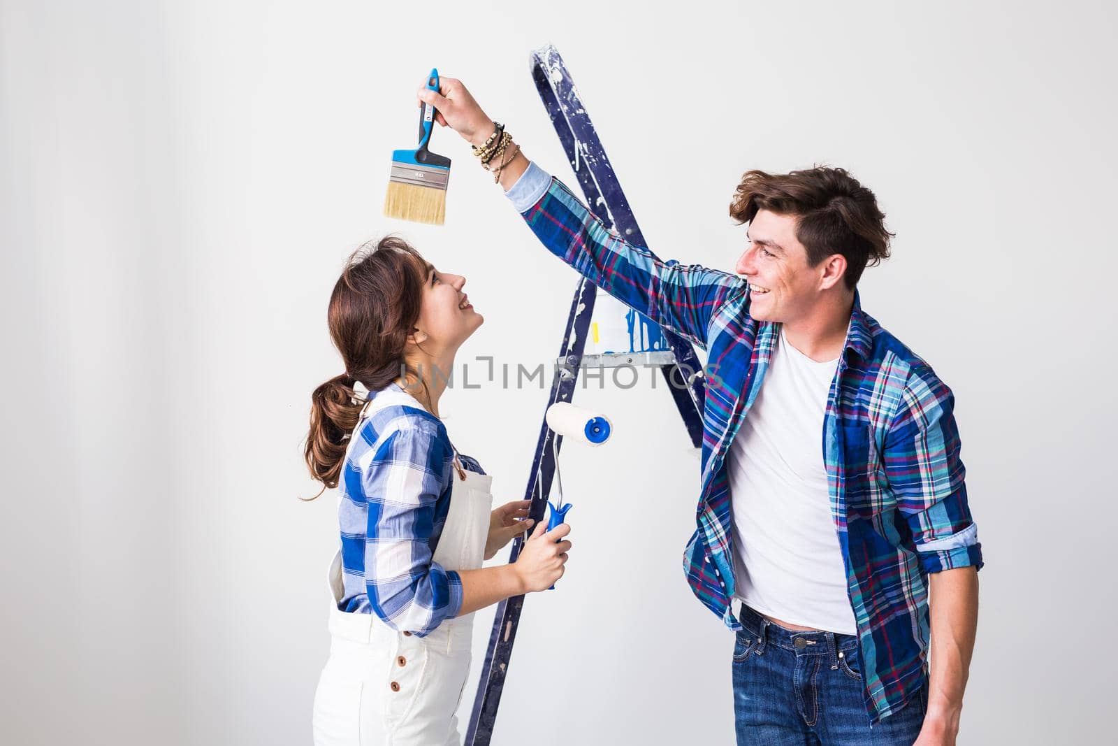 Teamwork, renovation and repair concept - Portrait of funny couple doing redecoration in apartment by Satura86