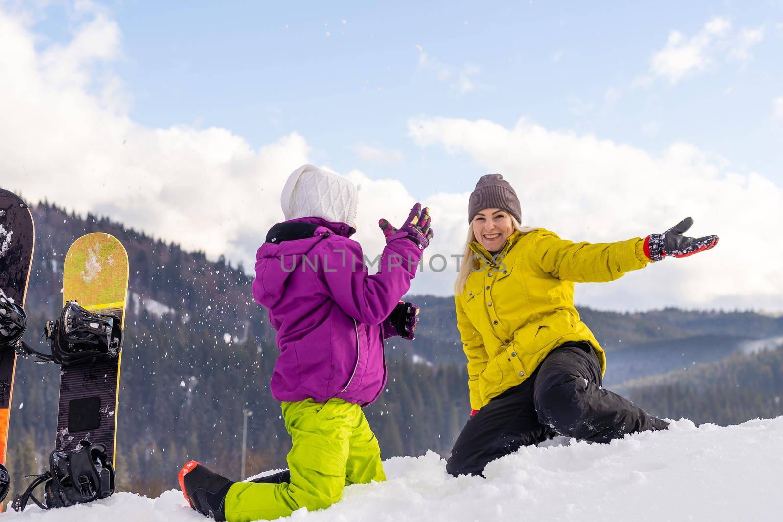 mother and daughter with snowboards at winter resort