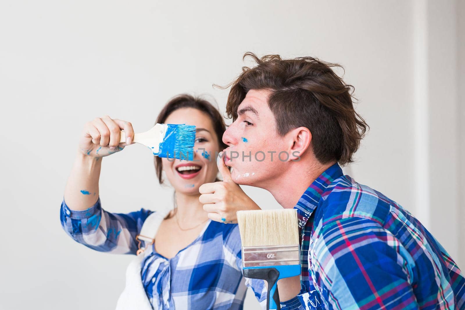 Teamwork, renovation and repair concept - Portrait of funny couple doing redecoration in apartment.