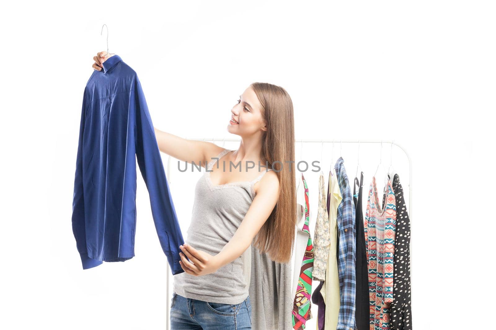 Portrait of satisfied young woman looking at blue man's shirt