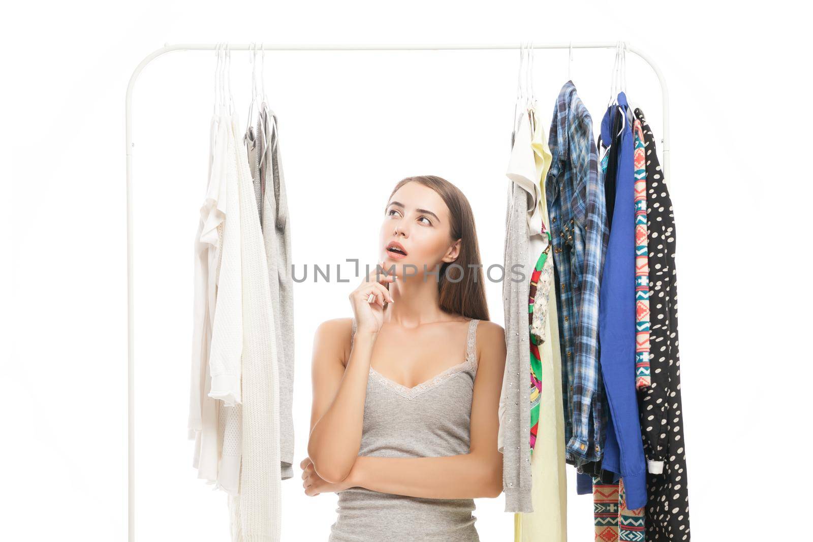 Portrait of thinking brunette woman looking at clothes