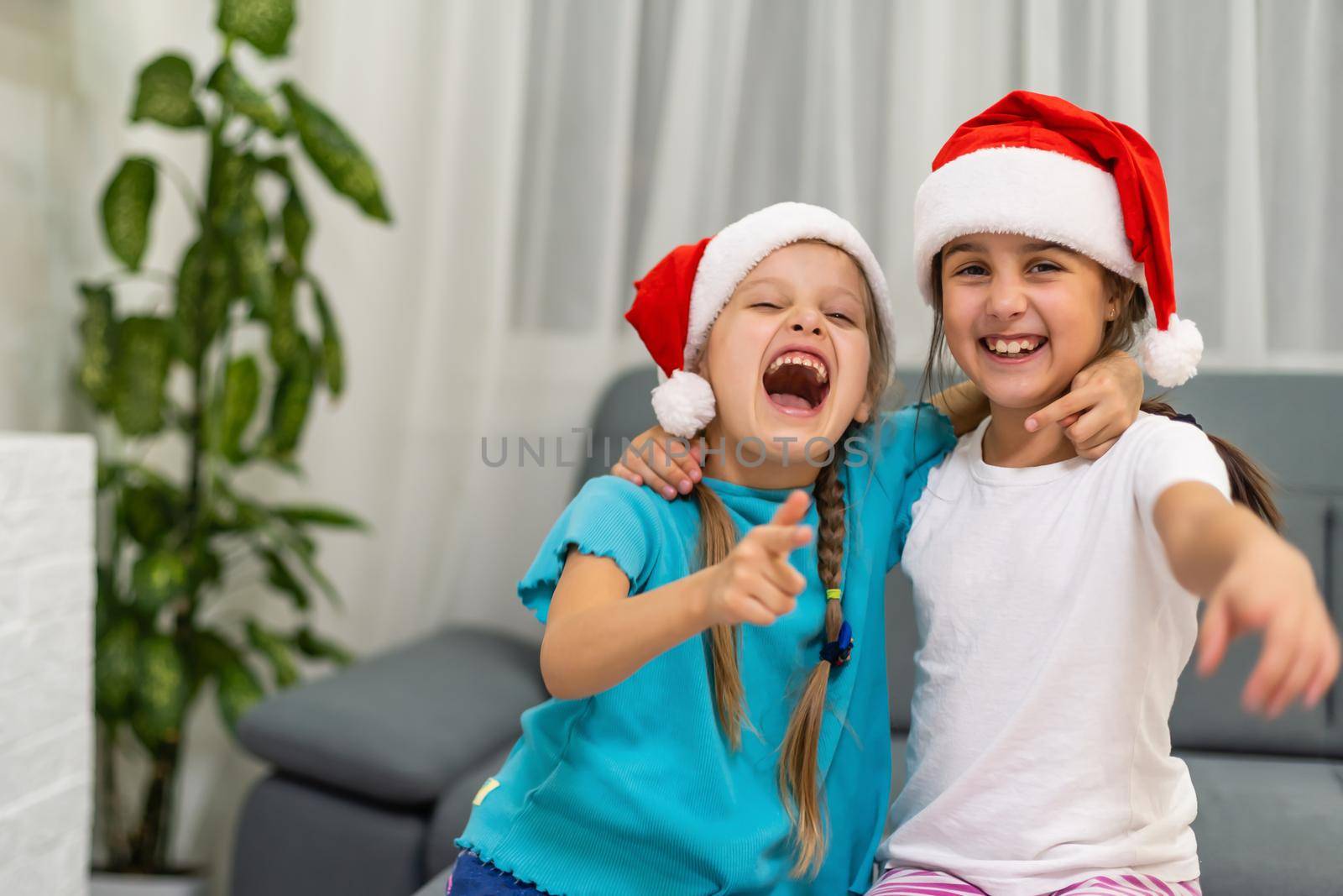 Two little girls in hats of Santa Claus