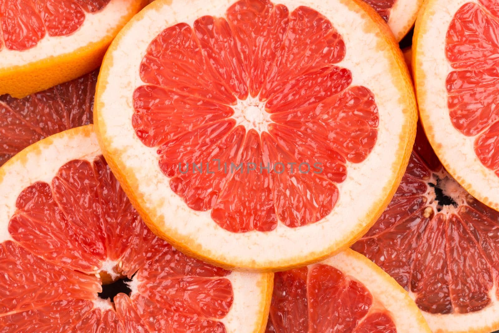 Abstract red background with citrus-fruit of grapefruit slices. Close-up