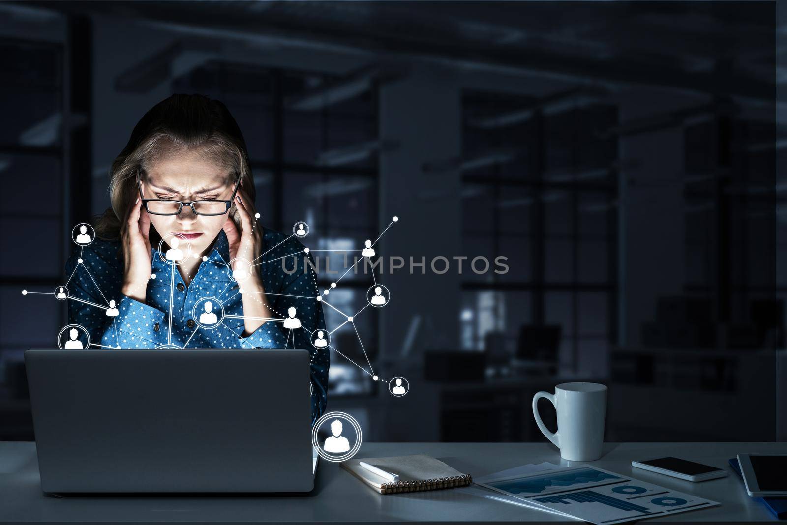 Attractive blonde wearing glasses in dark office using laptop. Mixed media by adam121