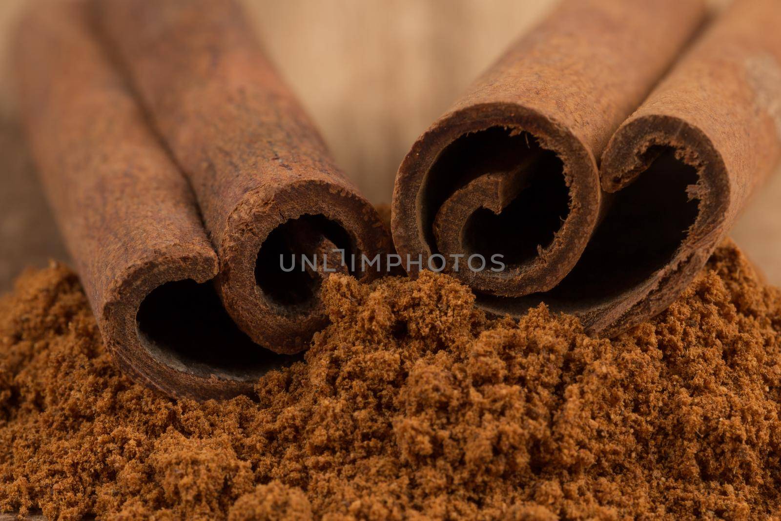 Cinnamon sticks with cinnamon powder on wooden background