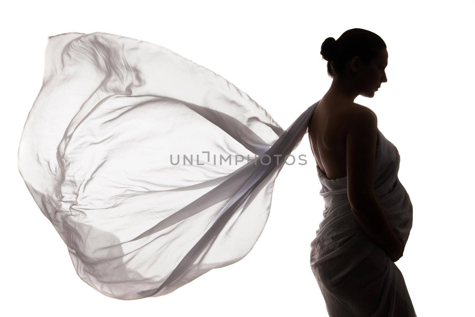 Portrait of beautiful pregnant woman in white chiffon shawl isolated over white background