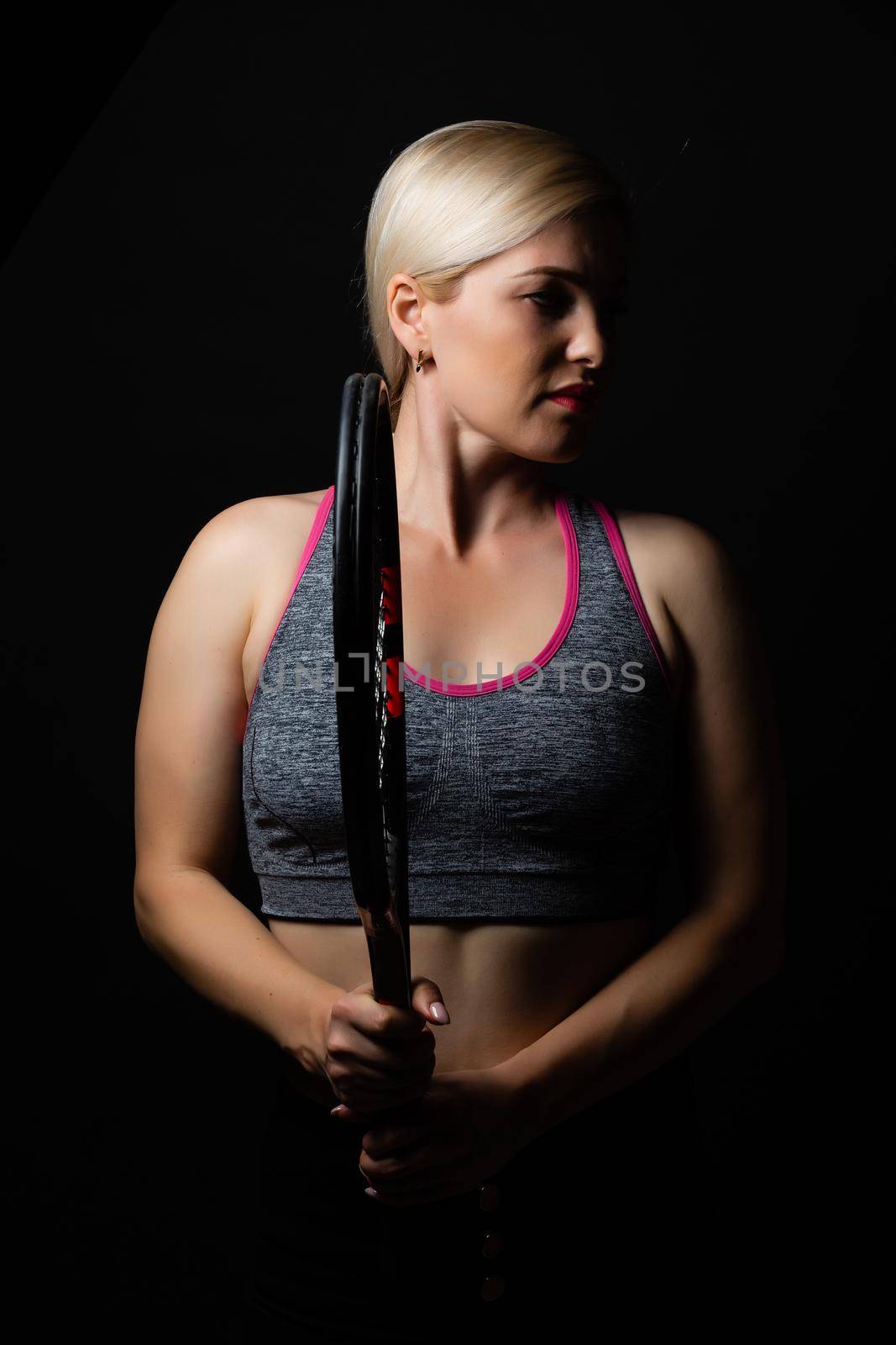 Female tennis player with racket and ball on black background by Andelov13