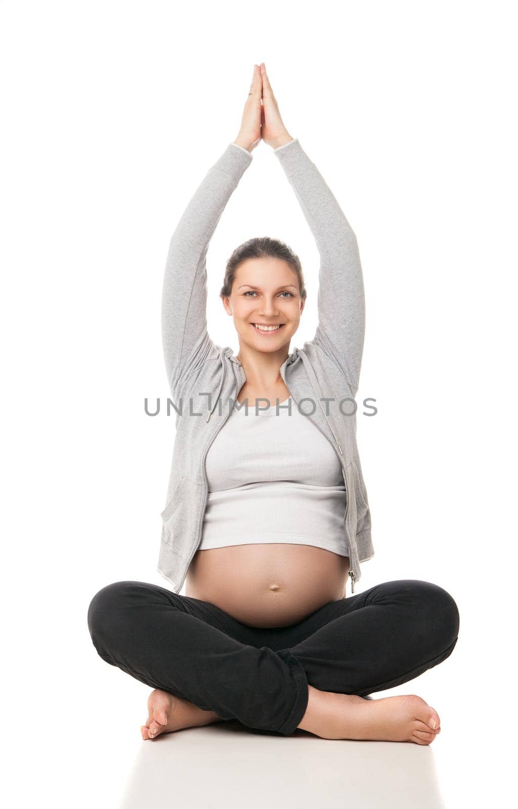 Pregnant woman relax doing yoga, sitting in lotus position over white background