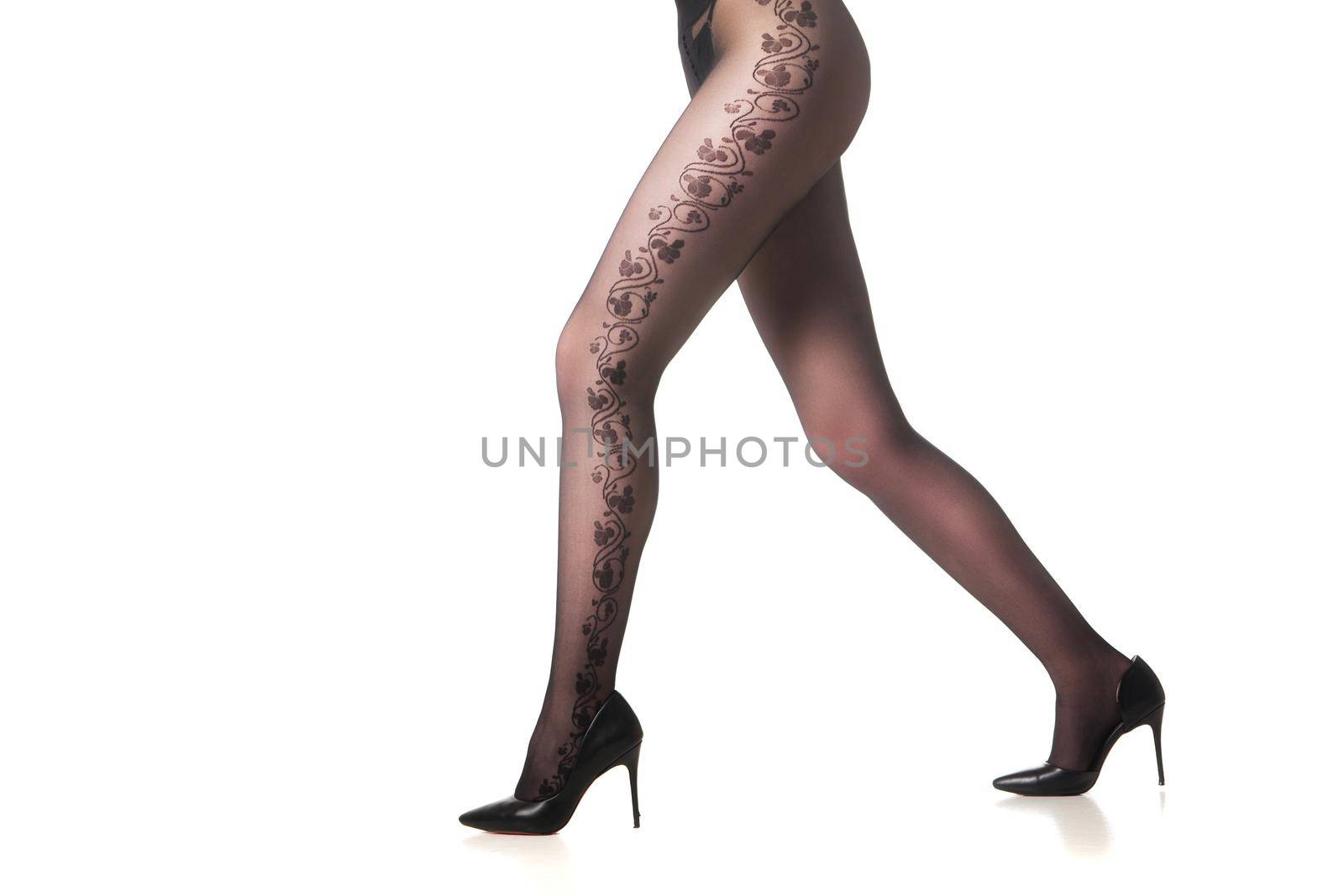 Hot woman legs wearing black pantyhose isolated on white.