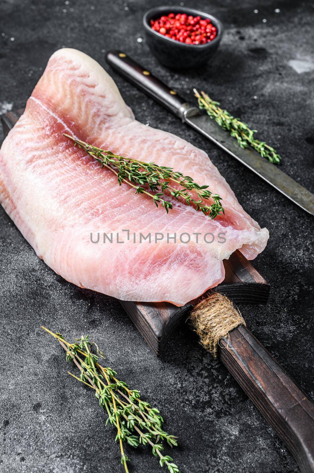 Fresh raw white fish fillet Pangasius with spices. Black background. Top view by Composter