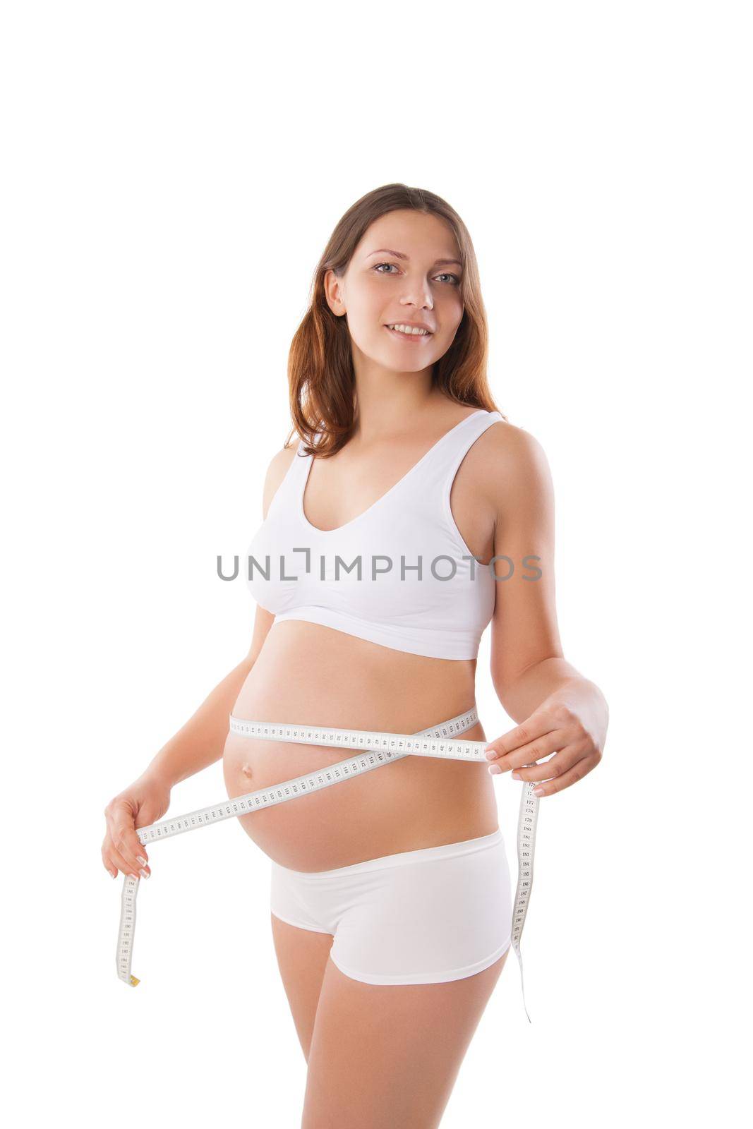 Pregnant woman measuring her stomach with tape measure