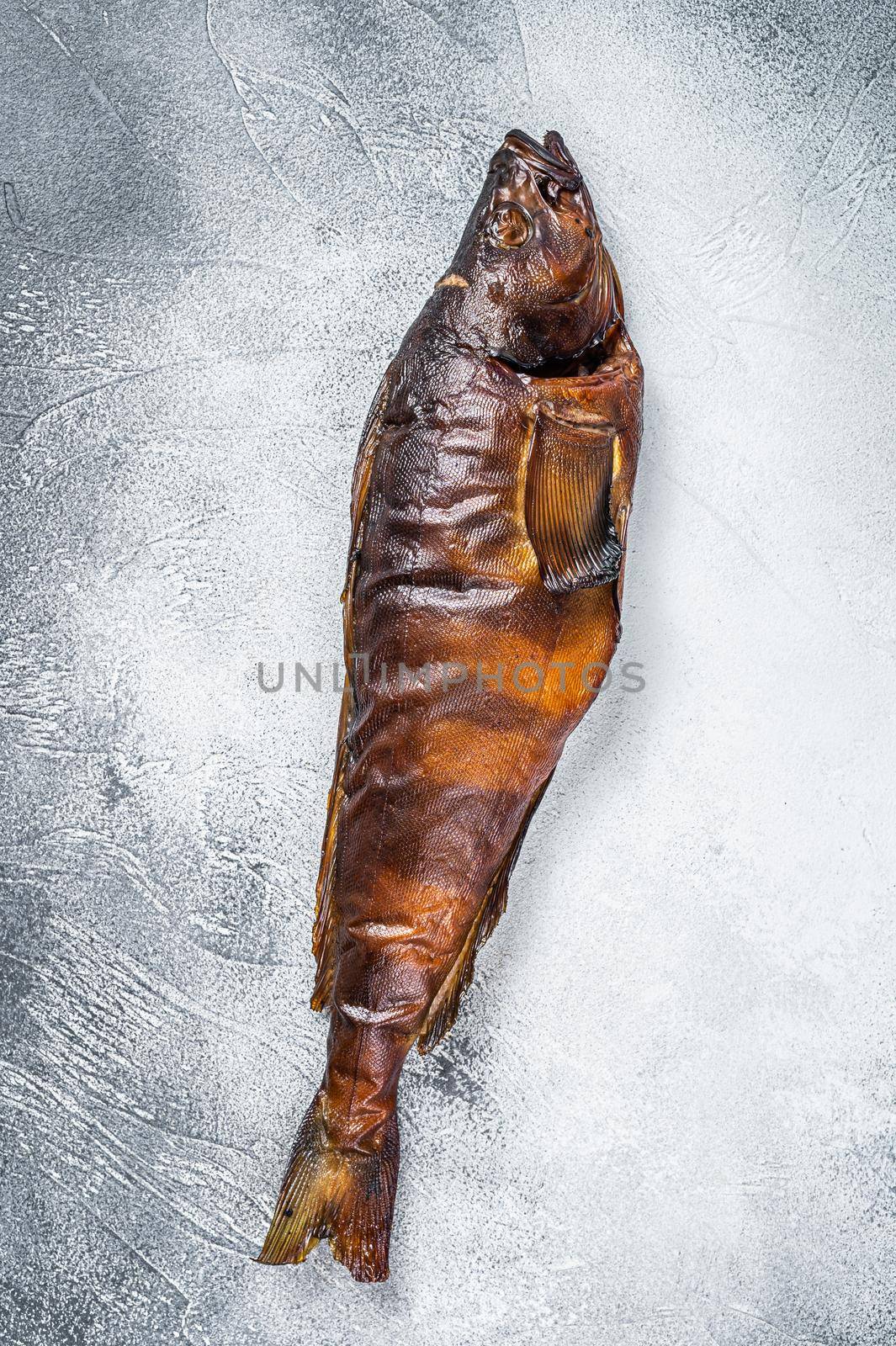 Hot smoked whole fish on kitchen table. White background. Top view by Composter
