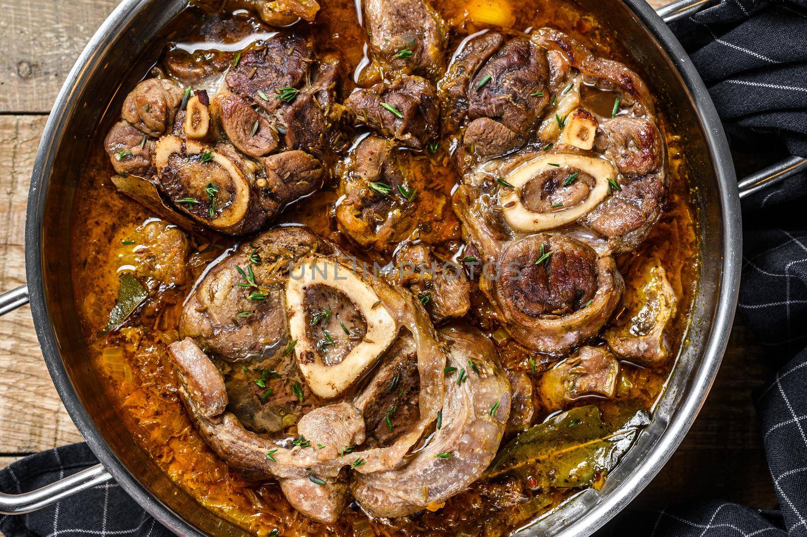 Stewed veal shank meat Osso Buco, italian ossobuco steak. wooden background. Top view by Composter