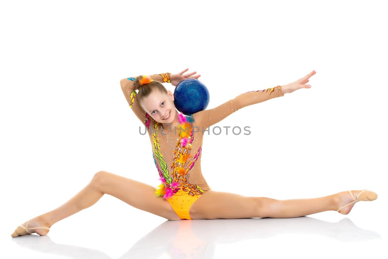 A girl gymnast performs an acrobatic element on the floor. The concept of childhood, sport, healthy lifestyle. Isolated on white background.