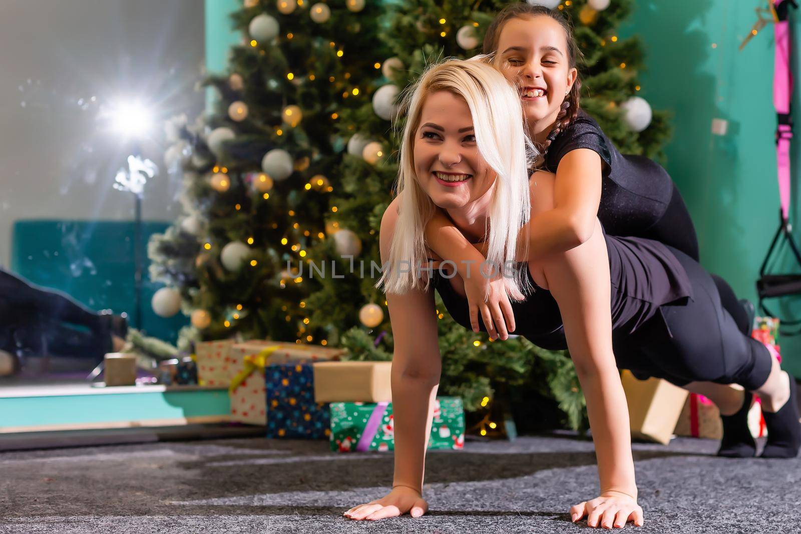 family doing fitness near the christmas tree by Andelov13