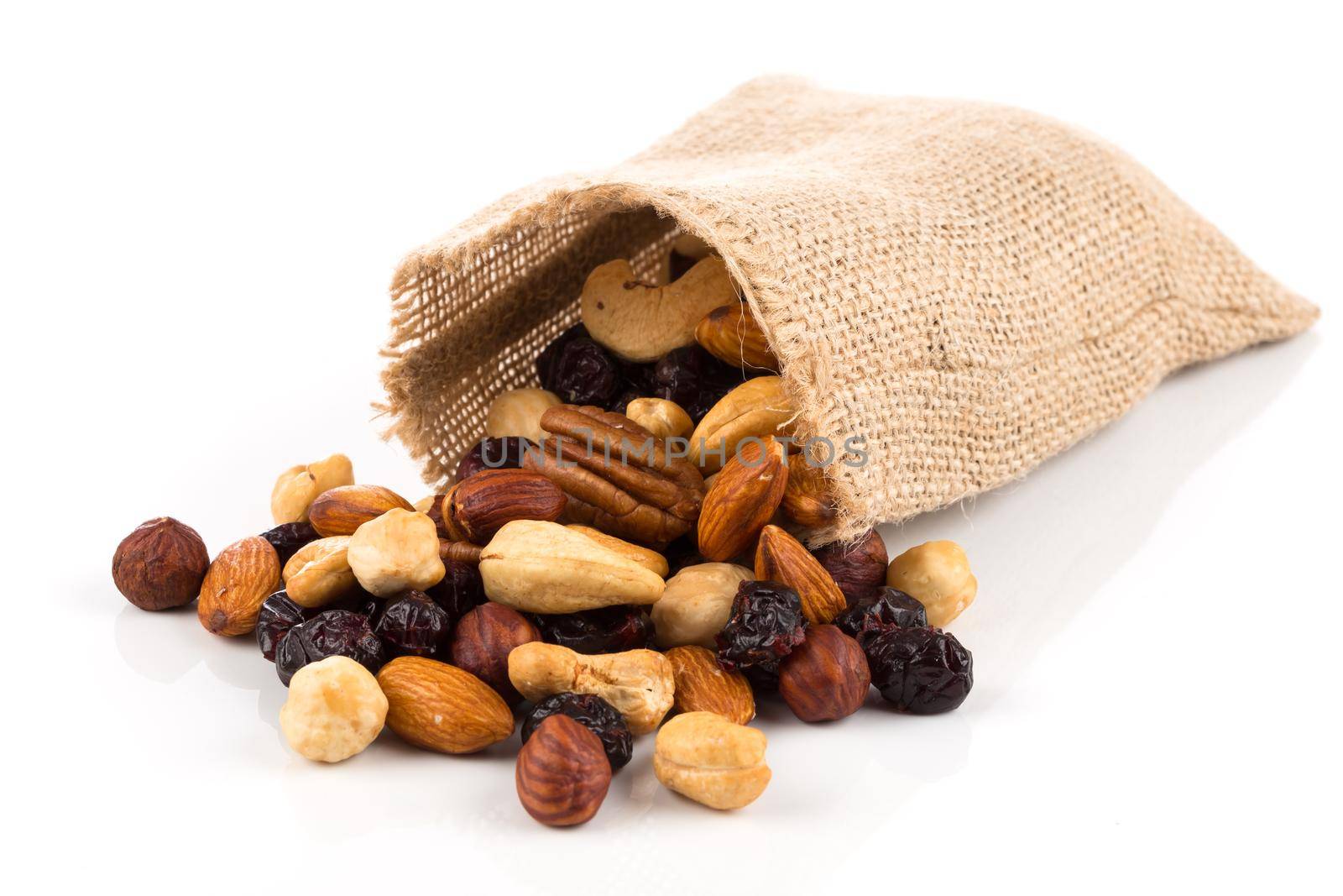 Mix nuts, dry fruits and grapes on a white background in hessian bag