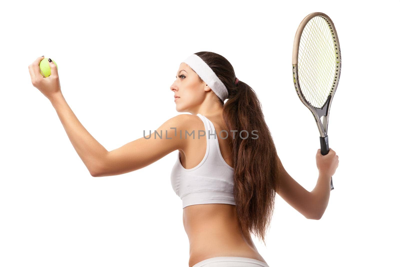 Adult woman playing tennis and showing her back. Studio shot over white.