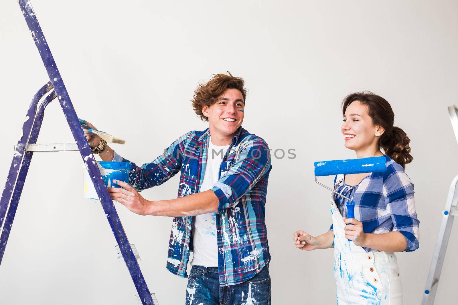 People, renovation and repair concept - Portrait of lovely couple doing redecoration in apartment.