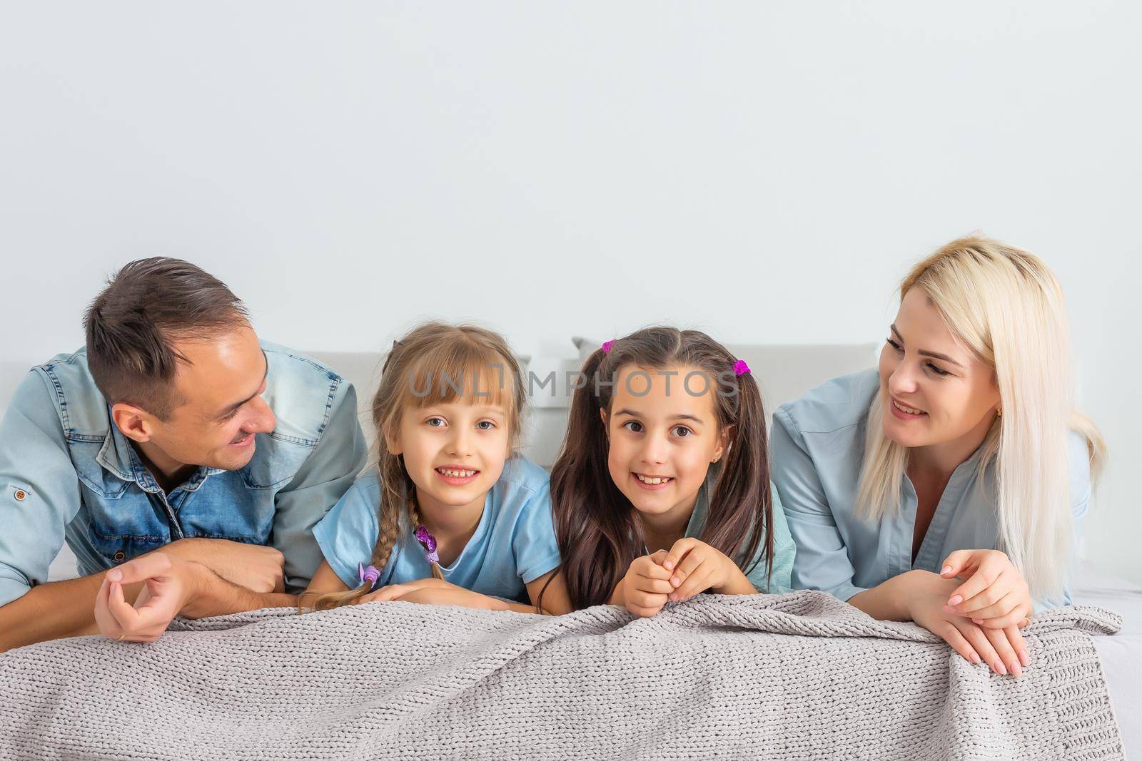 Happy family with children in bed