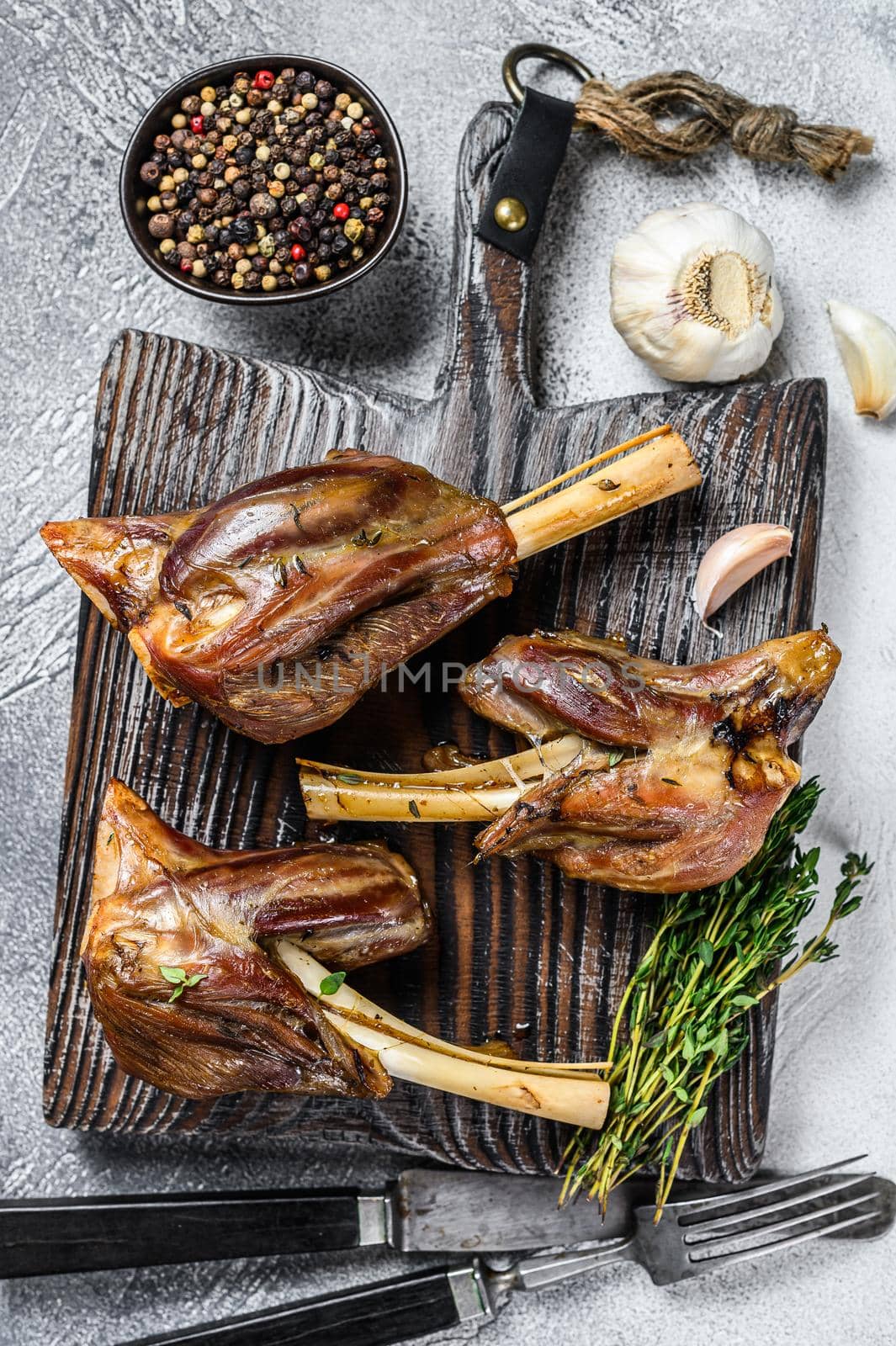 Braised roast Lamb Shanks on a wooden cutting board. White background. Top view.