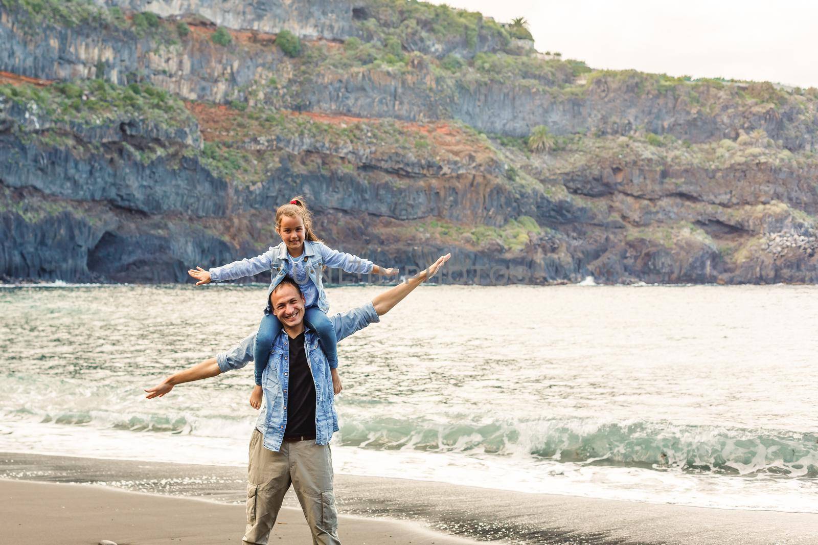 Happy family standing on the beach on the dawn time