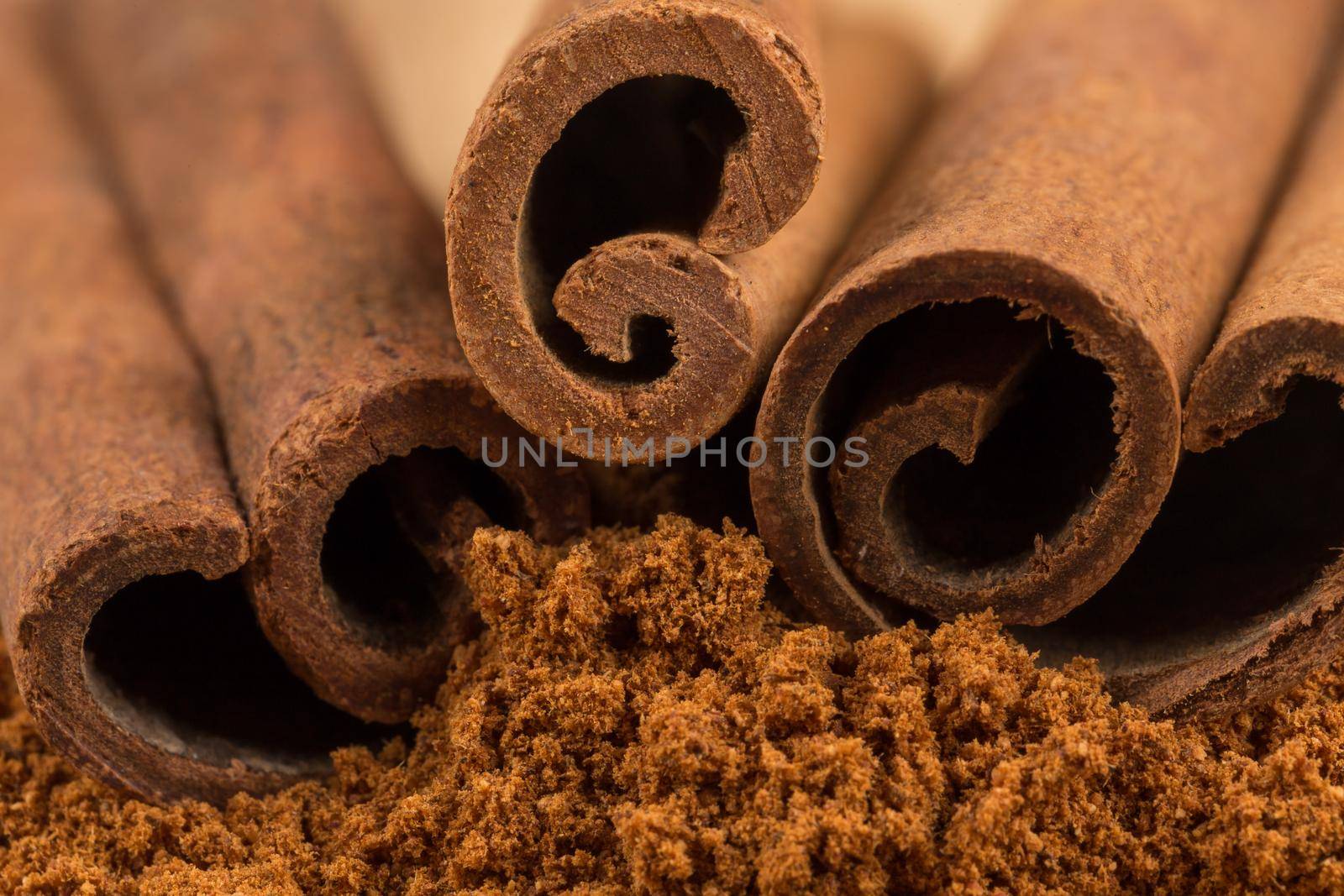 Cinnamon sticks with cinnamon powder on wooden background