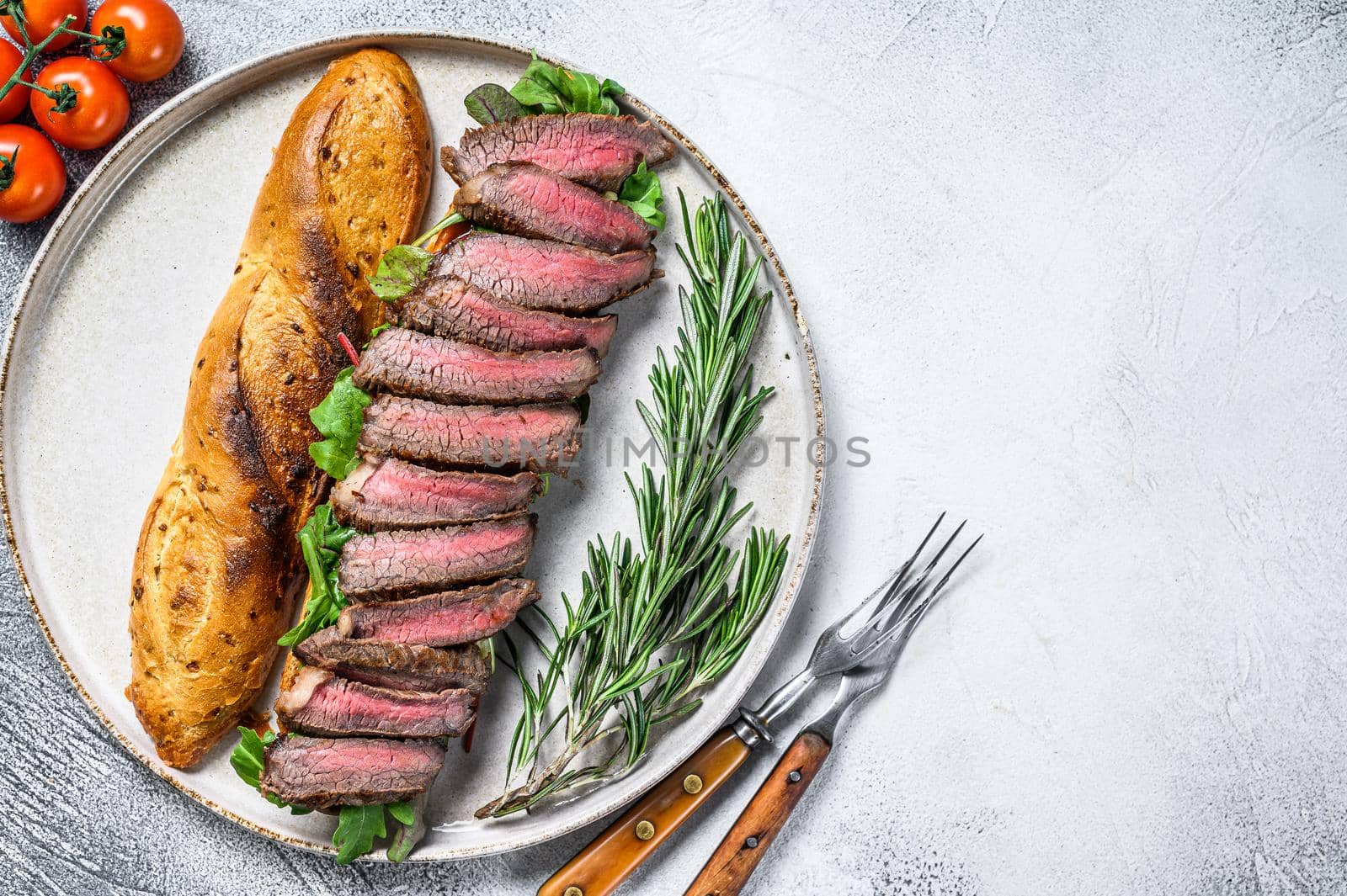 Grilled Homemade rib eye Steak sandwich with sliced roast beef, arugula. White background. Top view. Copy space.