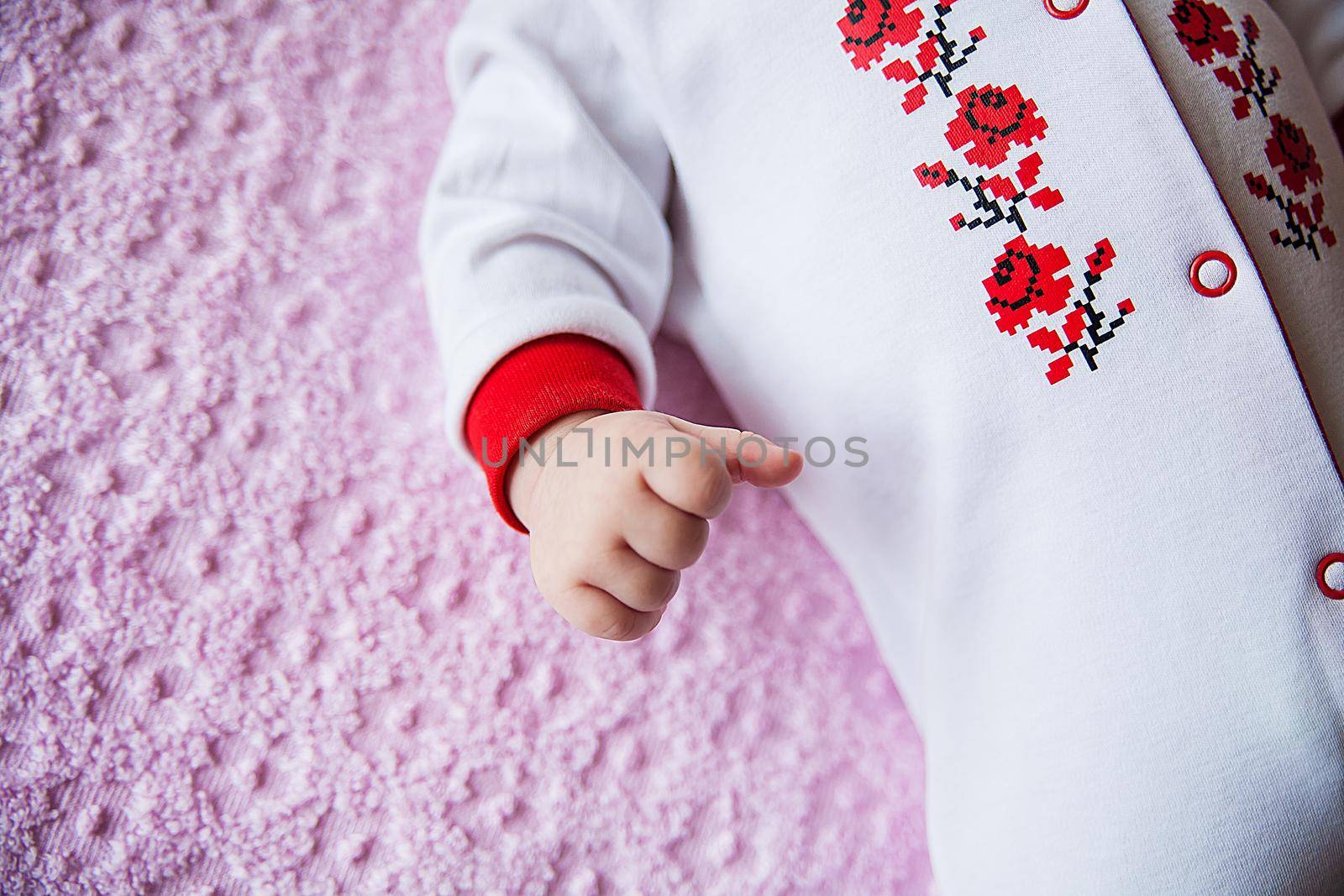 Newborn baby dressed in national costume with embroidery