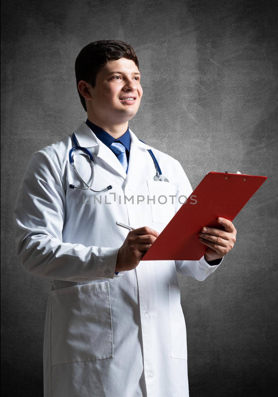 Doctor with tablet for documents, scans documents against the background of the wall