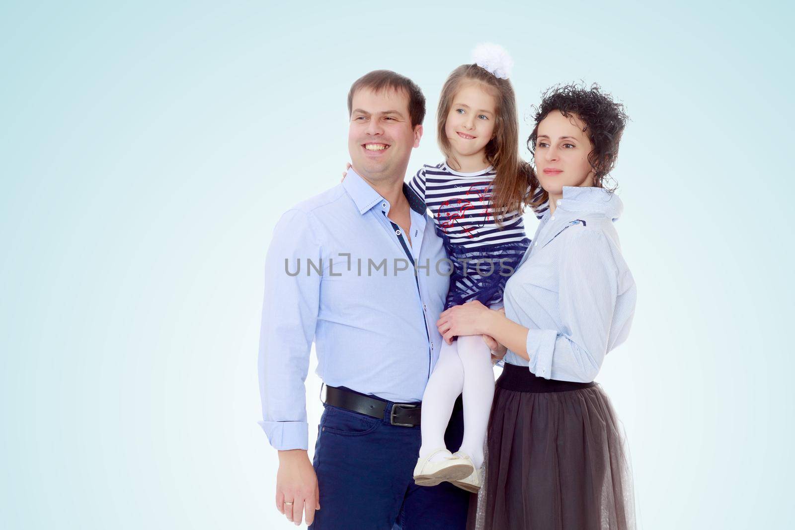 Happy young family, mom dad and little daughter.Parents keep the girl in her arms , and she hugs their neck.
