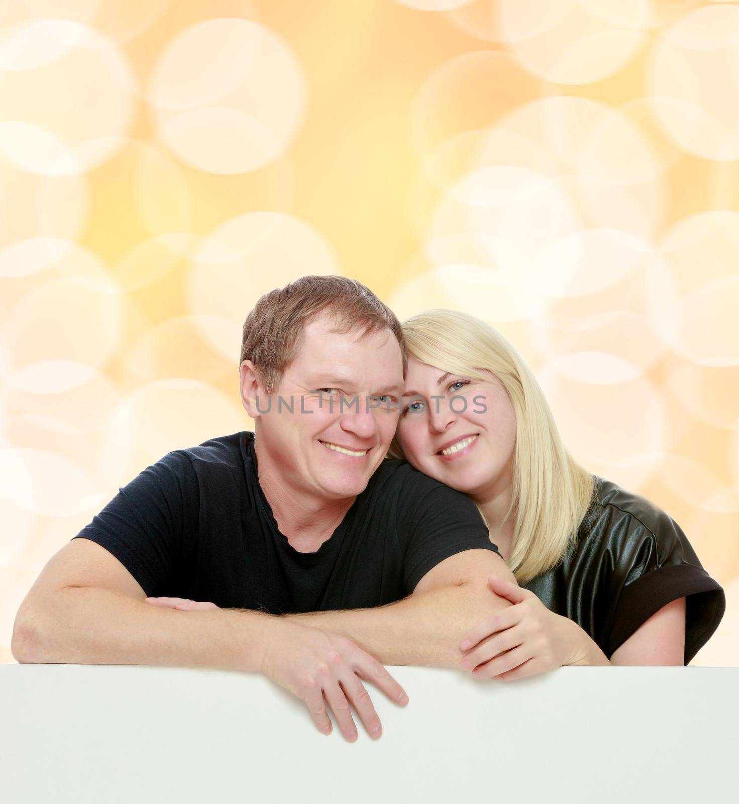 A man and a woman tenderly hugging each other. Peeping over white banner.Brown festive, Christmas background with white snowflakes, circles.