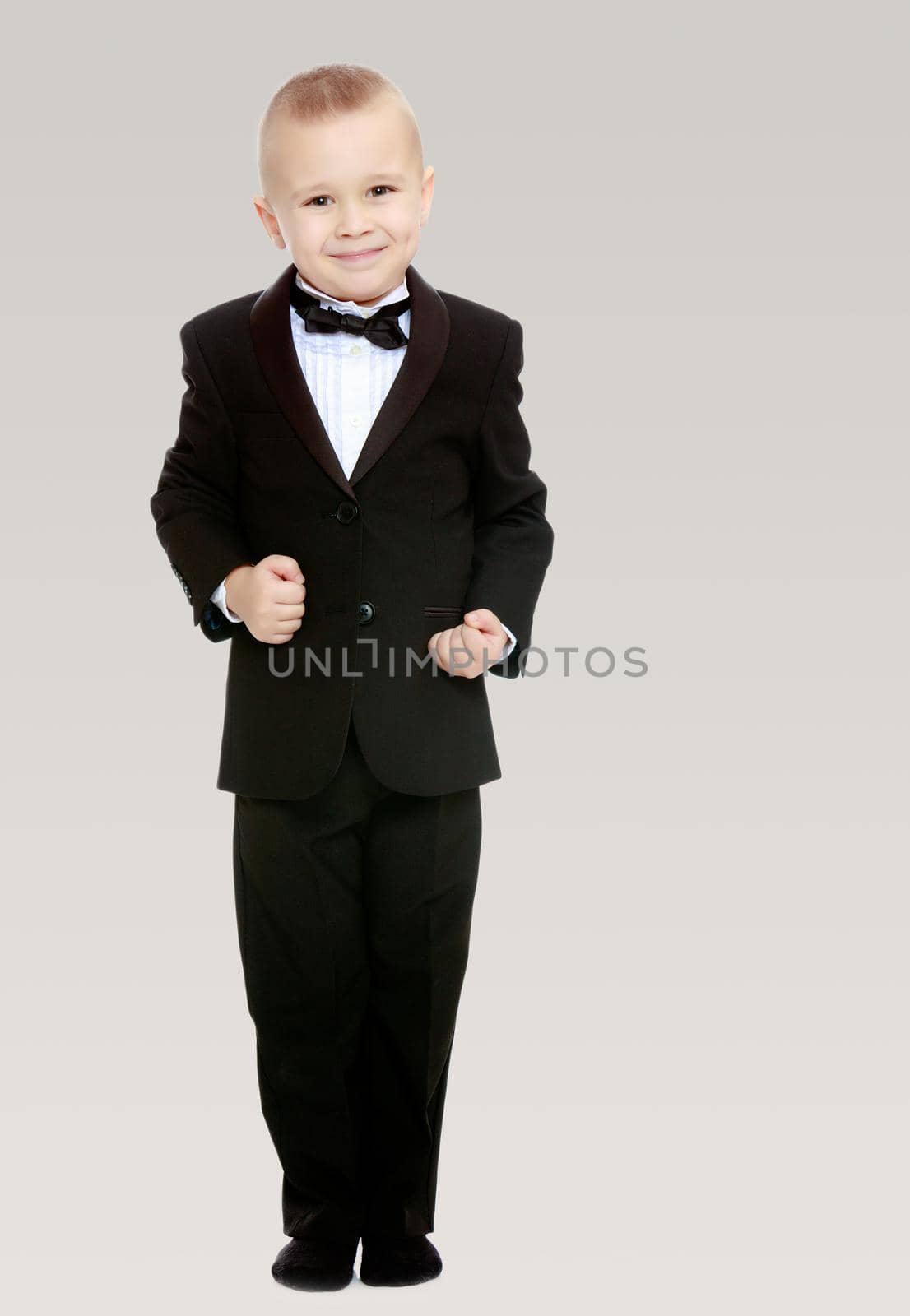 Trendy little boy in a black suit with a tie. by kolesnikov_studio