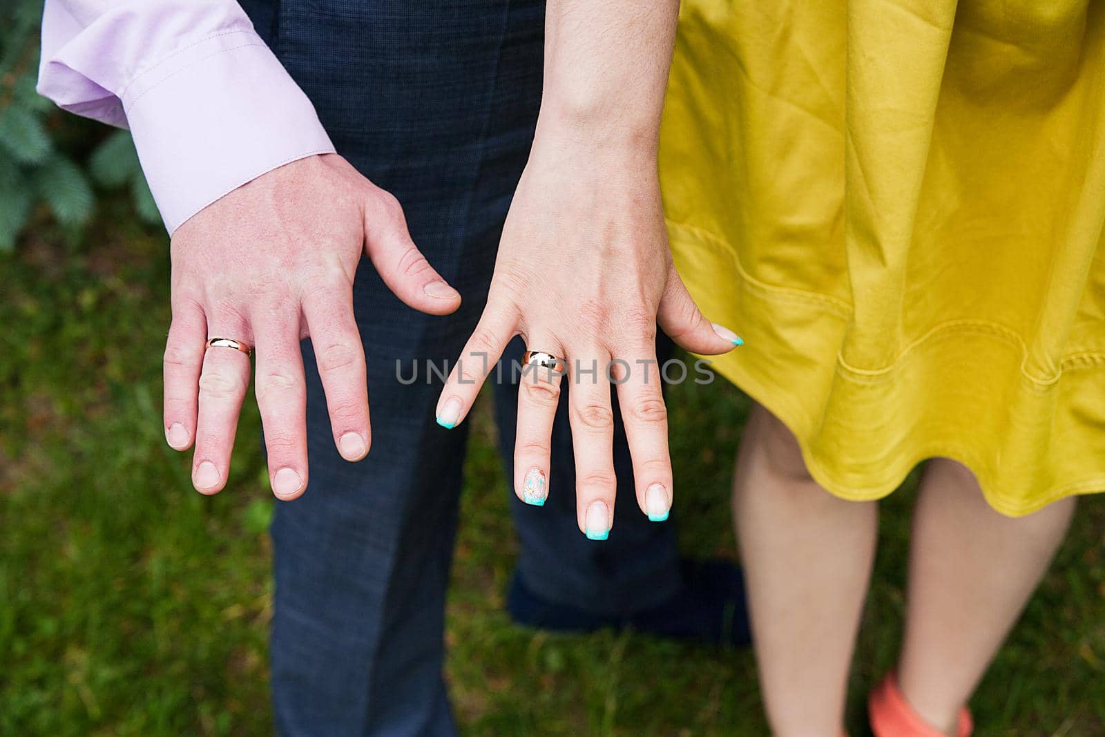 Closeup view of married couple holding hands.