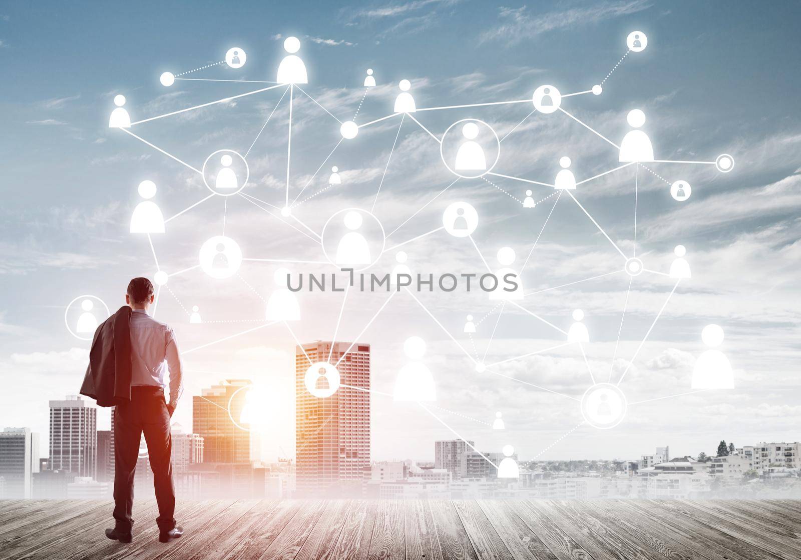 Back view of businessman looking at modern cityscape and connection concept