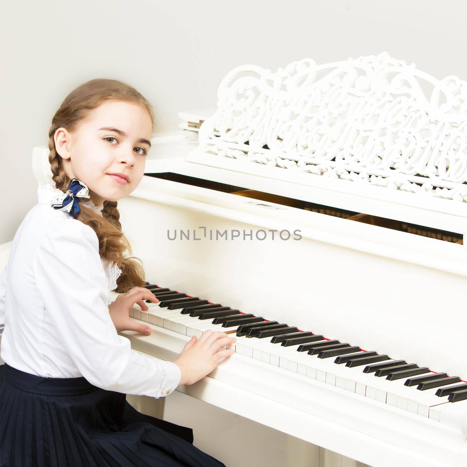 A girl from a music school plays the piano. by kolesnikov_studio