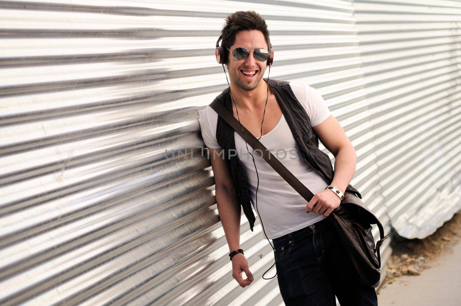 Portrait of young happy man smiling in urban background