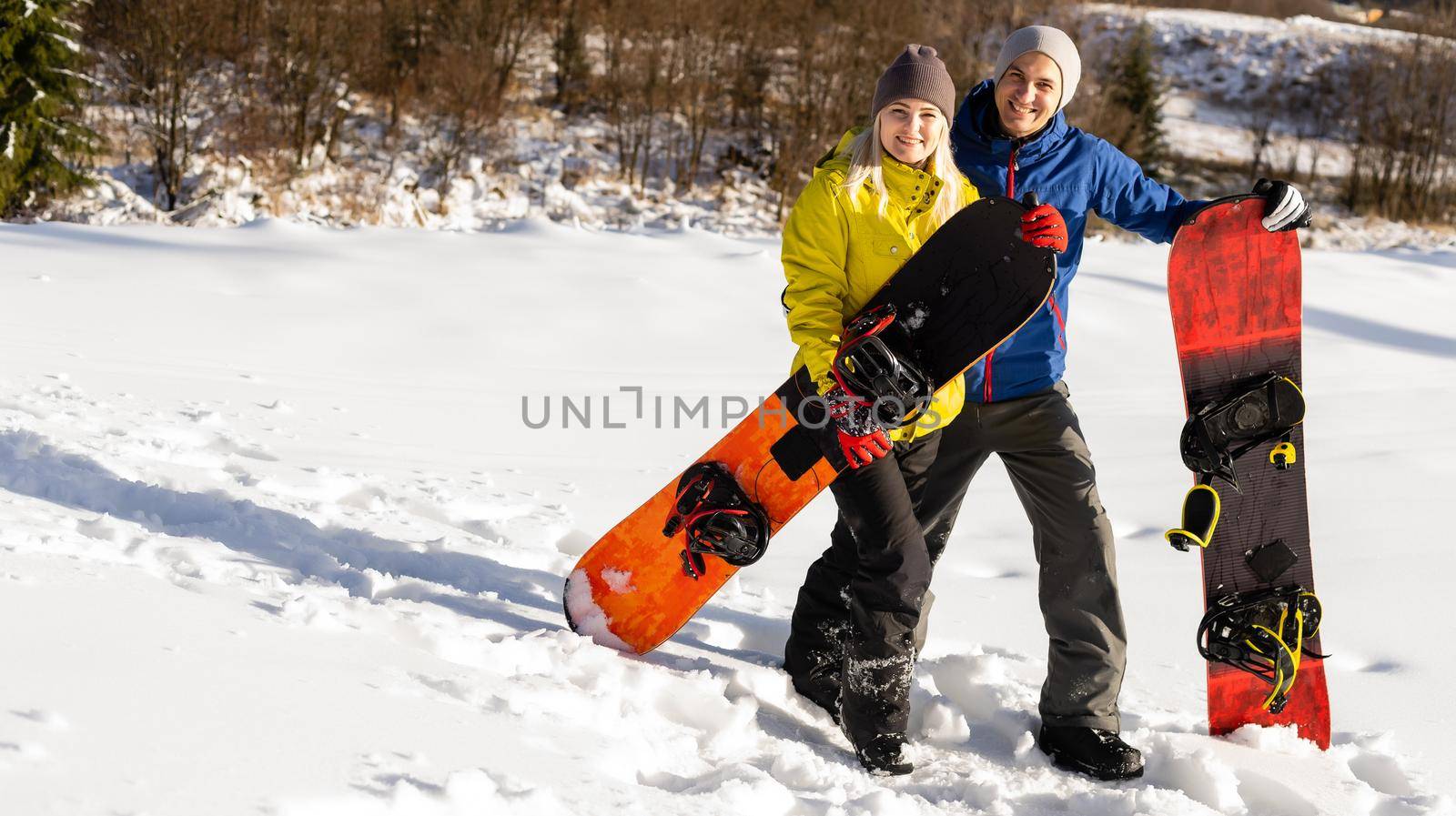 family with snowboards at winter resort playing in the snow by Andelov13