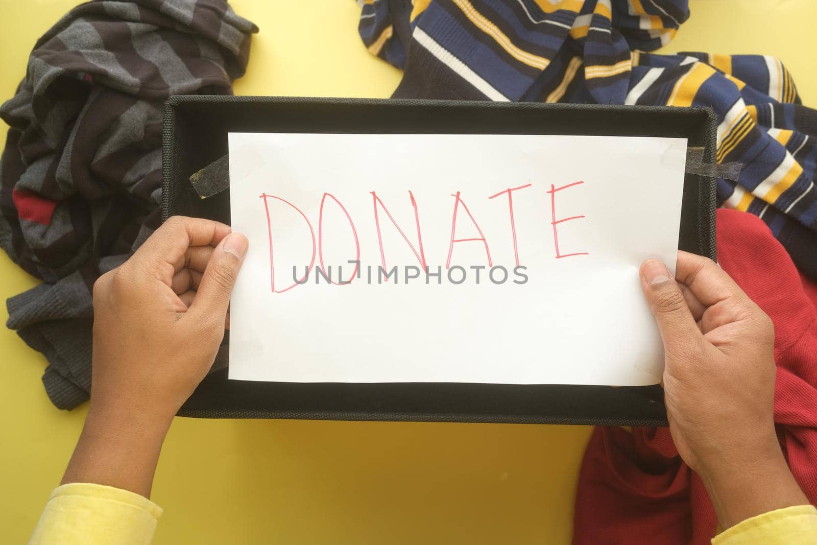 Donation box with donation clothes on a wooden background