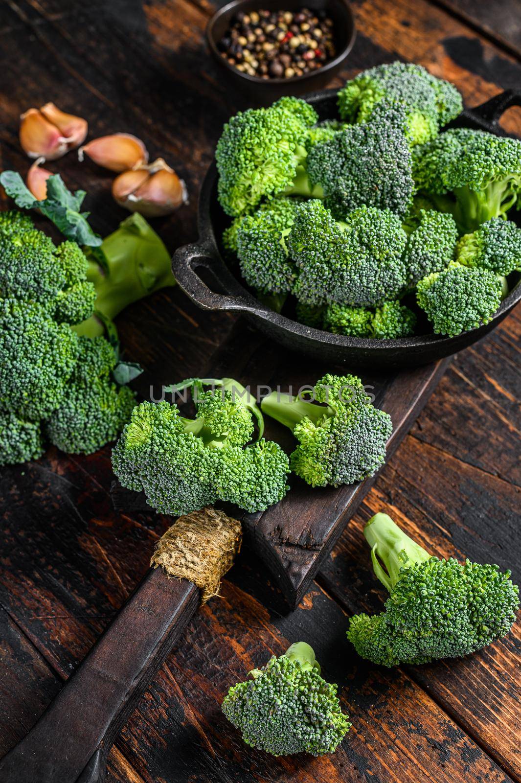 Raw green broccoli cabbage in a colander. Dark wooden background. Top view by Composter