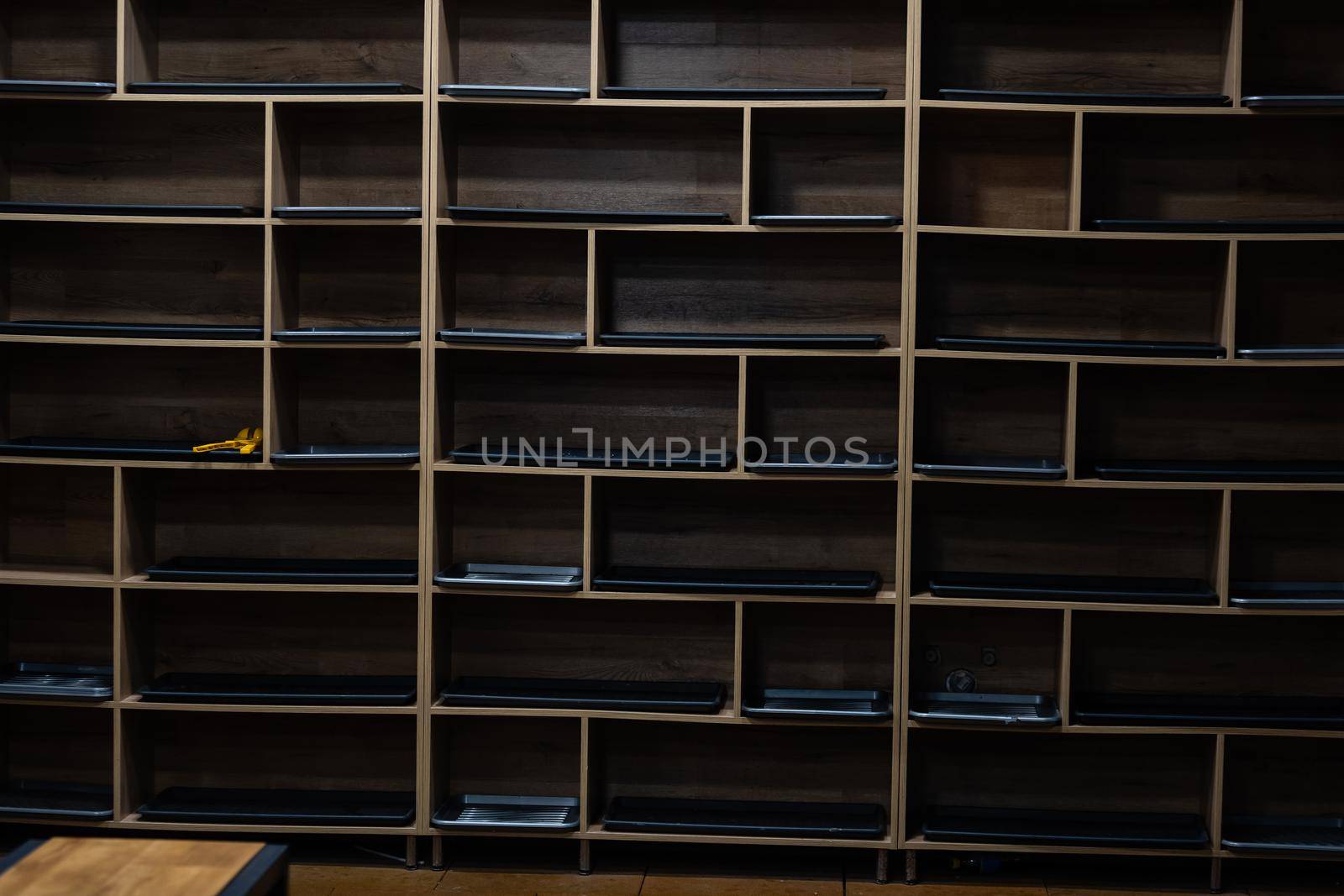 wooden shelf at black wall background.